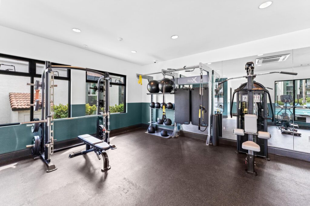 Gym with weightlifting bench, exercise machines, and free weights.